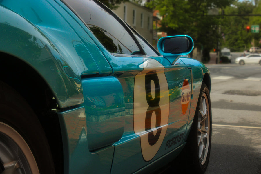 Close side view of turquoise number 8 Ford GT at a street corner, photographed by Jordan Lombard